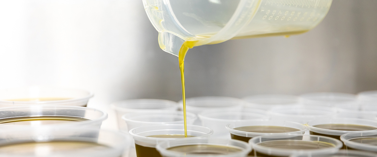 a jug pouring bush medicine oil into containers